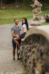 Young couple in love spending time together near the big old bridge