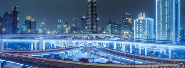 aerial view of buildings and highway interchange at night in Shanghai city