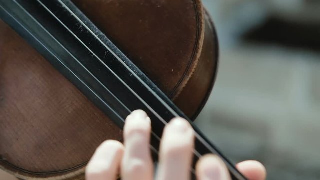 Close up Woman violinist playing the violin on the nature. Musician playing. Slow motion.
