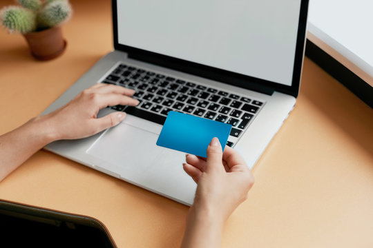 Woman holding credit card and using laptop. Online shopping concept