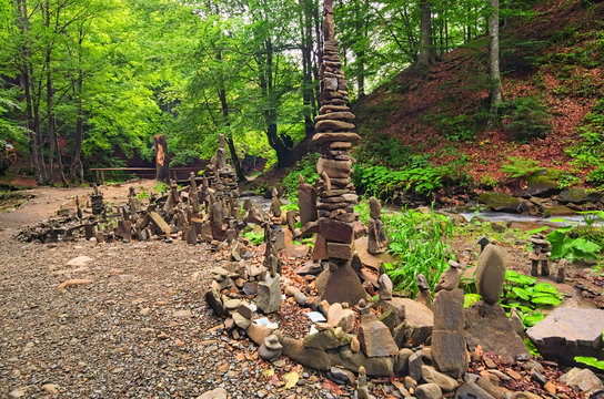 Balancing stones near waterfall Shypit. Stack of stone in summer morning forest. Zakarpattya, Ukraine