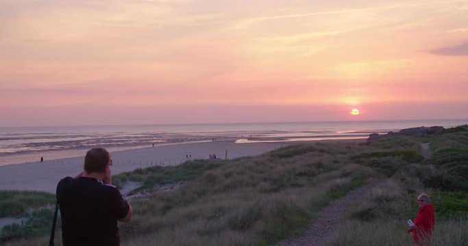 Gold hour sunset in Denmark Scandinavia Europe on beach with people walking
