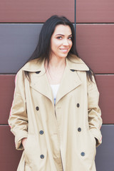 Beautiful woman in the beige coat and jeans on the street