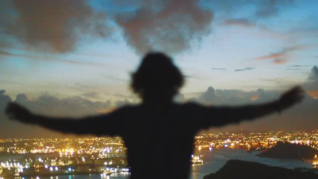 In this cinematic shot you can see silhouette of human with hands raised in the air and beautiful sunset panorama in the horizon. 
Willemstad, Curacao