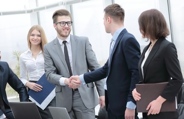 handshake business partners at a meeting in the office