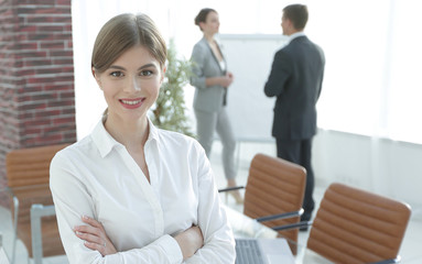 young woman assistant standing near desktop.