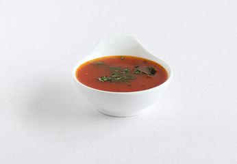 Tomato rasam, a traditional, popular and healthy south Indian vegetarian semi-liquid food is consumed as an appetizer or eaten with mixing the rasam with rice, in a bowl.