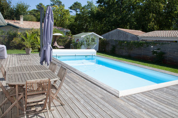 a beautiful pool in the garden of the house with a wooden deck