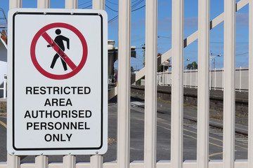 a black, white and red Restricted Area, Authorised Personnel Only warning sign on a fence - obrazy, fototapety, plakaty