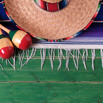 Mexico cinco de mayo fiesta carnival traditional green wood background border mexican sombrero maracas serape rug or blanket photo square format