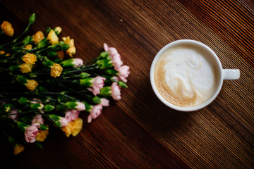 Cup of cappuccino and flowers.
