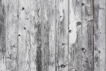 closeup of old grungy vertical planks with peeling white paint