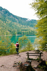 Fototapeta na wymiar girl hiker in the park. Glade in the park for recreation, place for a picnic in the forest. Nice view of the lake, quiet meadow for relaxing and meditation. girl sitting on bench and rest 
