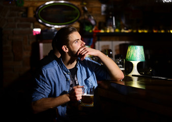 Guy sitting at bar counter and drinks beer.