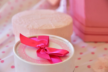 Round box of the present with the ribbon on the table