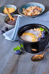 Yogurt with muesli and blueberries with mint, healthy dessert on wood
