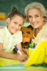 Grandmother with little girl doing homework 