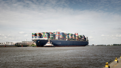 Containerschiff auf der Elbe zusammen mit einem Schlepper