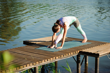 Fototapeta na wymiar Young woman doing yoga in morning park