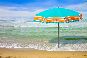 Calm sea with beach umbrella - concept image with copy space