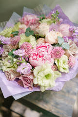 Beautiful summer bouquet. Arrangement with mix flowers. Flower bunch with peony on wooden table. The concept of a flower shop. Content for the catalog