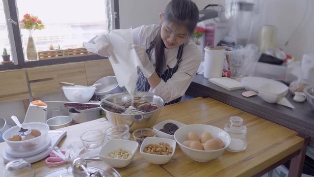 4K Movie of Asian Beautiful female chef cooking and baking browine cake in the kitchen
