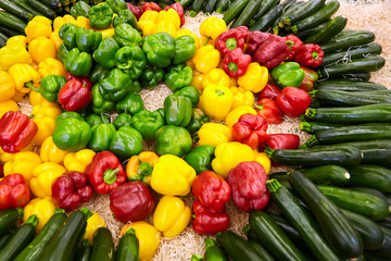 Zucchini, yellow, green and red sweet bell peppers  on a counter in the supermarket