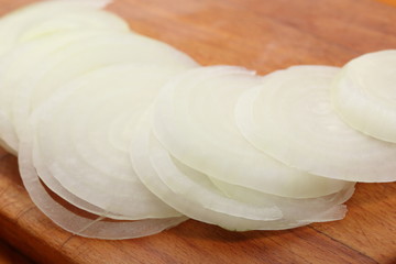 Obraz na płótnie Canvas Sliced onions lie on a wooden cutting board. Selective focus
