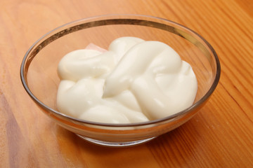 Fototapeta na wymiar Mayonnaise in a small glass bowl on a wooden table