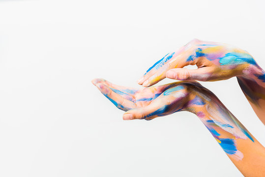 cropped image of girl with colorful bright body art making waves with hands isolated on white