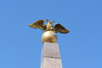 Golden two-headed eagle sculpture on obelisk