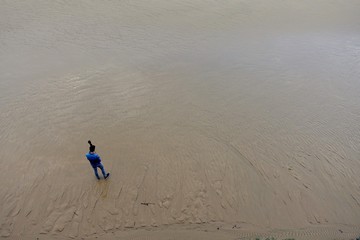 Man walking on an empty beach in San Sebastian