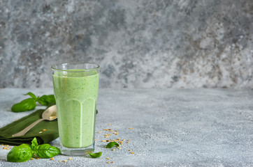 Vegetable smoothies from yogurt, spinach, basil and avocado with chia seeds on a concrete background. Detox drink. Proper nutrition.
