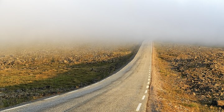 Road through a barren plateau, European route E69, fog, midnight sun, North Cape, Mageroya island, Finnmark County, Norway, Europe
