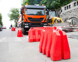 Plastic road barrier (water-filled road fence) standing on the road against the back of a lorry