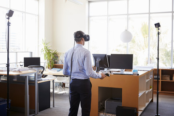 Businessman using VR technology in an office, back view