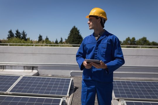 Male worker using digital tablet at solar station