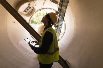 Male worker using digital tablet while examining a concrete