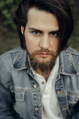  A large-sized portrait of a bearded dark-haired guy in a blue jeans similar to Jared Leto
