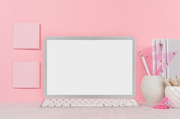 Back to school background for girl's - white stationery, blank laptop computer and stickers on soft pink wall and white wood desk.
