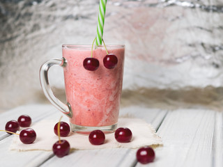 Milkshake or cherry smoothie on white wooden table. Wholesome breakfast