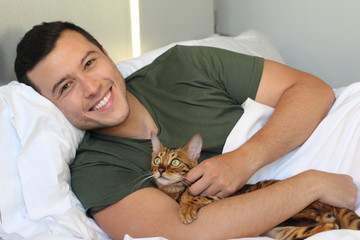 Cute ethnic man sleeping with his cat