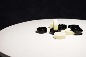 Obraz na płótnie Canvas Game checkers on a white round table.