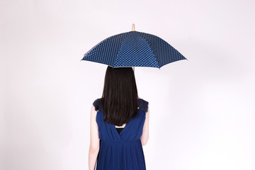 Rear view of business woman back holding an opening umbrella in white isolated background.
