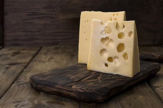 A beautiful Swiss cheese with holes, a useful dairy product. Tasty food. Country style photo. Place for text. Copy space.