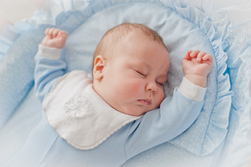 Baby's restful sleep. Newborn baby in a wooden crib. The baby sleeps in the bedside cradle. Safe...