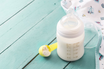 Baby bottle and milk on blue wooden table. Copyspace