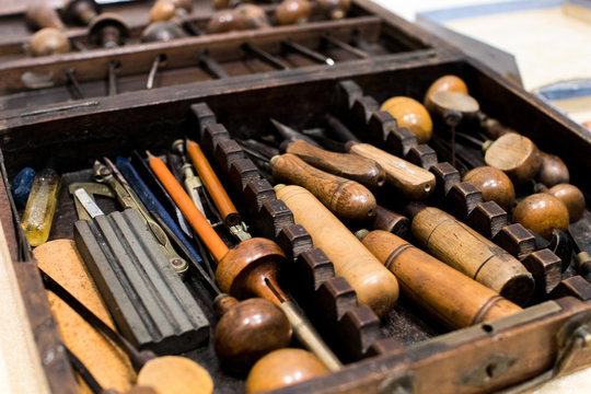 Antique tools for engraving and printing in a wooden case. Tools for typographers and artists to make prints, lithographs, etchings and engravings. Ancient art and craftsmanship
