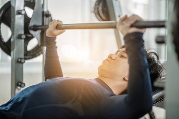 Bench Press Exercise.Brutal athletic man pumping up muscles on bench press.Concept of healthy lifestyle. Cross fit bodybuilder in the gym.