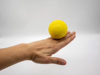 Yellow stress ball stay on the back woman hand isolated on white